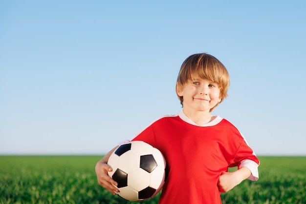 Das kind gibt vor, ein fußballspieler zu sein