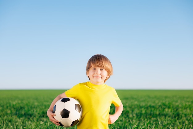 Das Kind gibt vor, ein Fußballspieler zu sein