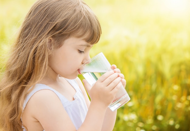 Das Kind hält ein Glas Wasser in den Händen. selektiver fokus.