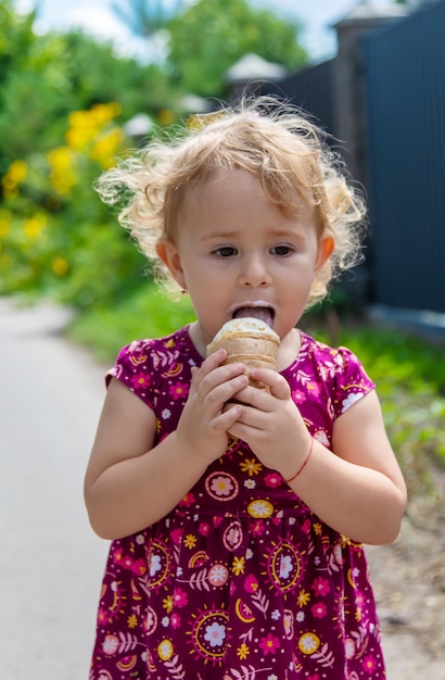 Das Kind isst Eis auf der Straße Selektiver Fokus