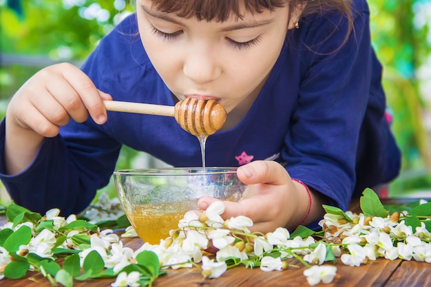 Das Kind isst Honig. Selektiver Fokus Natur.