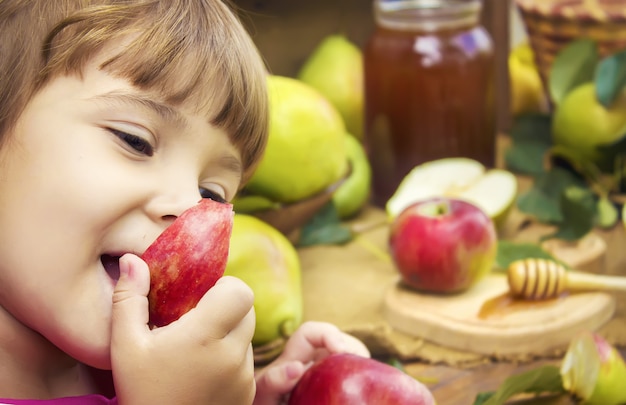 Das Kind isst Honig und Äpfel. Selektiver Fokus