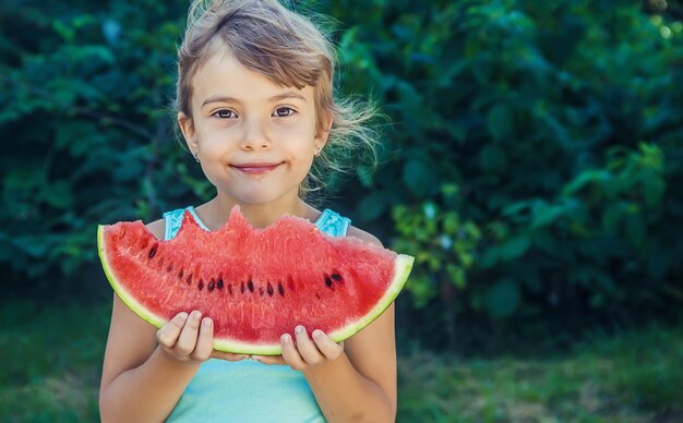 Das Kind isst im Sommer Wassermelone. Selektiver Fokus.