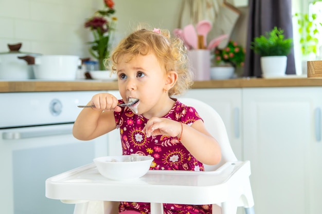 Das Kind isst Knödel am Tisch Selektiver Fokus