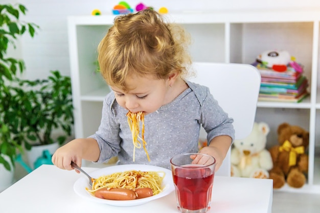 Das Kind isst Spaghetti-Mittagessen Selektiver Fokus