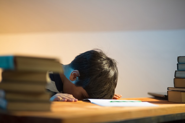 Das Kind legte während des Unterrichts aus Müdigkeit seine Stirn auf den Tisch. Er ruht sich aus