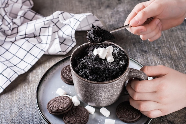 Das Kind nimmt einen Löffel Schokoladenkuchenbecher zum Nachtisch