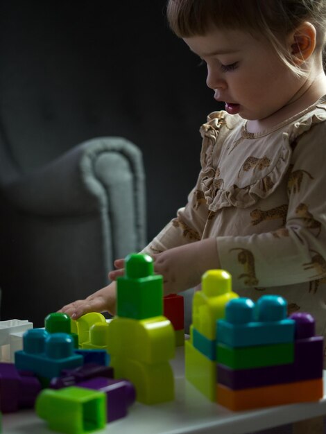 Das Kind sammelt den Designer am Tisch im Kinderzimmer