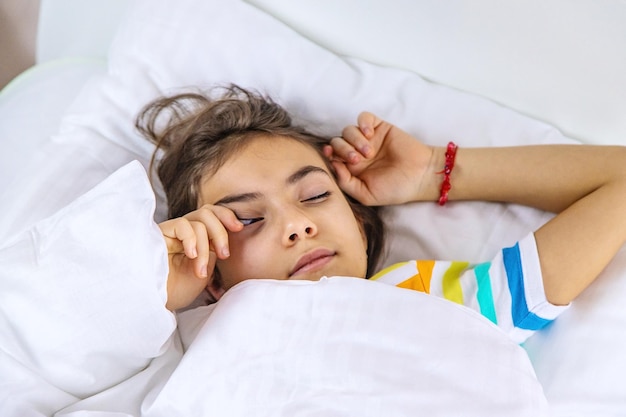 Das Kind schläft morgens im Bett Selektiver Fokus