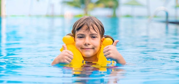 Das Kind schwimmt im Sommer im Pool