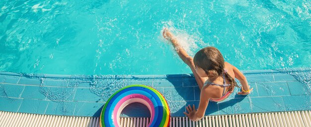 Das Kind schwimmt und taucht im Pool.