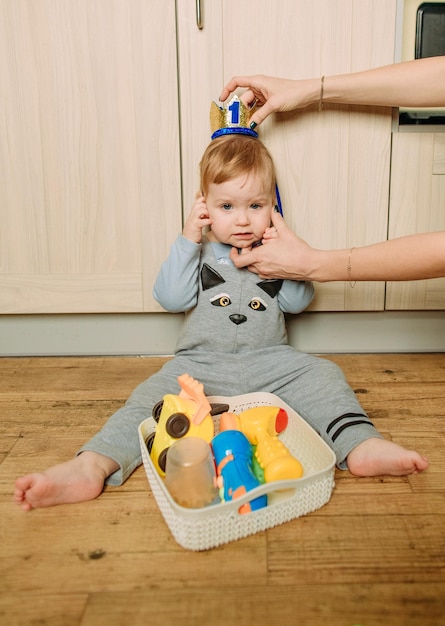 Das Kind sitzt in der Bodenküche und spielt Spielzeug