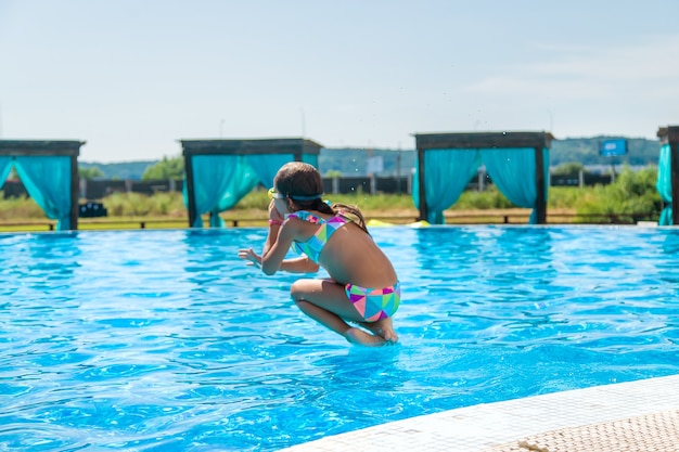 Das Kind springt in den Pool. Selektiver Fokus. Kind.