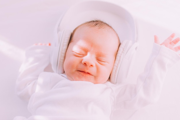 Das Kind trägt Kopfhörer Happy Baby Ein neugeborenes Baby