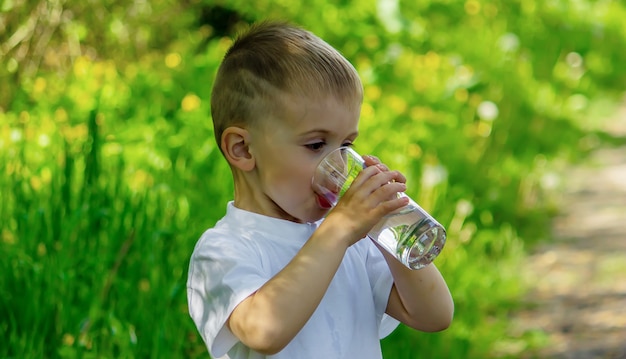 Das Kind trinkt im Sommer sauberes Wasser