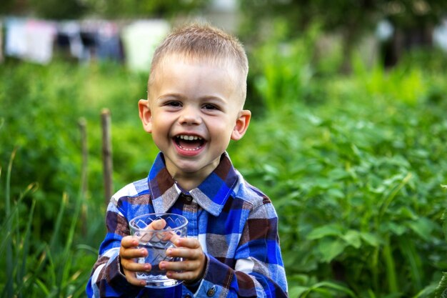 Das Kind trinkt sauberes Wasser in der Natur.