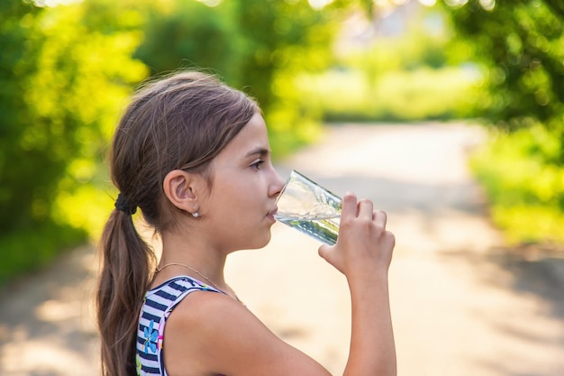 Das Kind trinkt Wasser aus einem Glas Selektiver Fokus