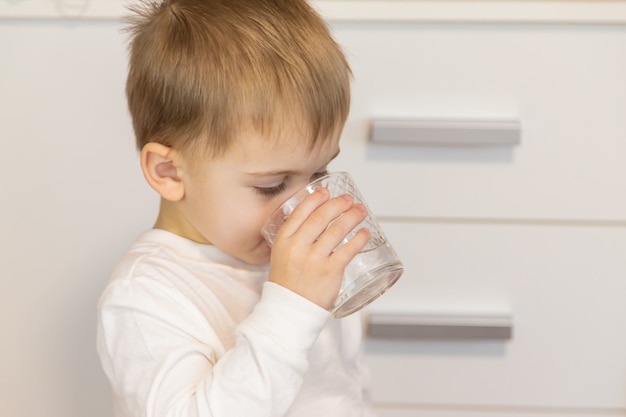 Das Kind trinkt Wasser aus einem Glas