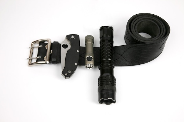 Das Klappmesser, eine Taschenlampe und ein Taser an einem schwarzen Lederarmband