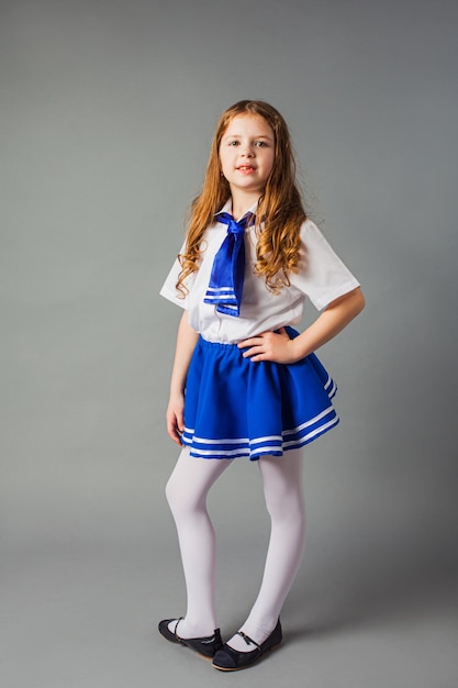 Das kleine Mädchen posiert in einem Matrosenkostüm