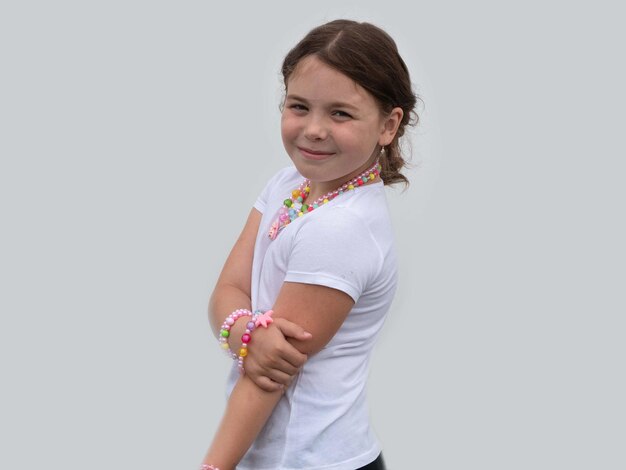 Das kleine Mädchen trägt viele bunte Perlen und Armbänder, die sie selbst gemacht hat