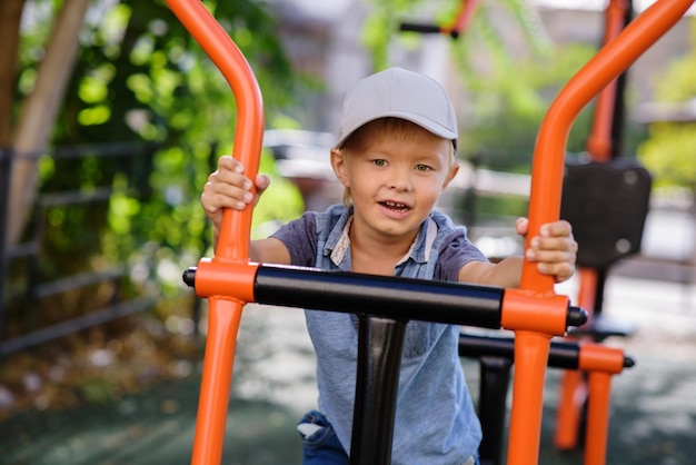 Foto das kleinkind läuft auf einem trainingsgerät auf dem spielplatz