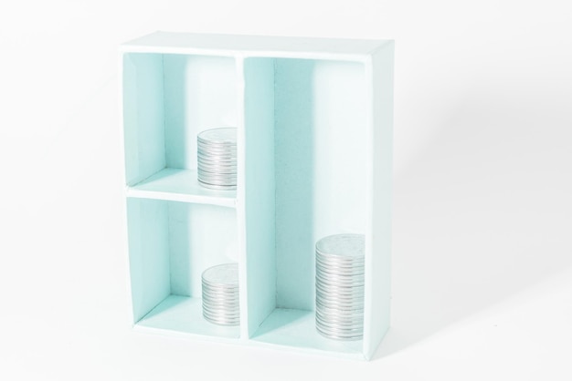 Das Konzept der Geldanlagen Einsparungen Stapel von Münzen in einem Schrank auf weißem Hintergrund