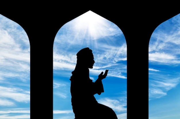 Das Konzept der islamischen Religion. Silhouette eines Mannes, der im Rathaus betet