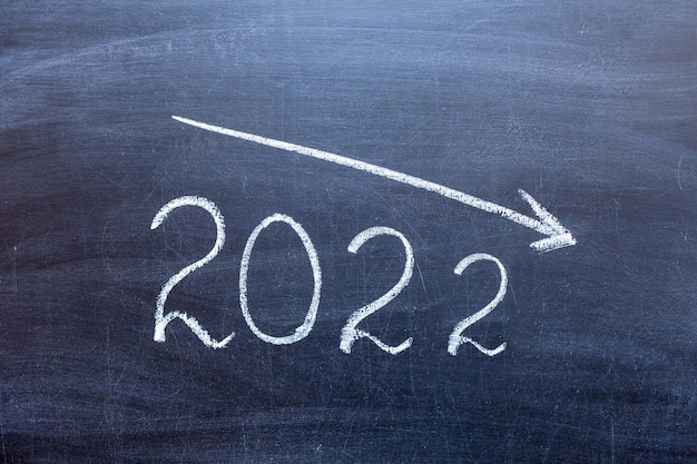 Das Konzept der Krise von 2020. 2020 auf einer Kreidetafel mit einem Pfeil nach unten