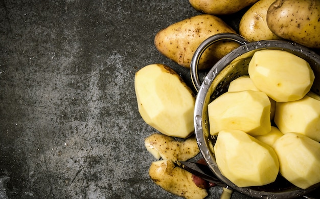 das Konzept der nassen geschälten Kartoffeln auf einem Steinhintergrund