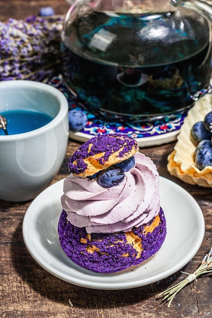 Das Konzept des romantischen Tees Französischer Shu-Kuchen Lavendeltee Blaubeeren festliches Dekor