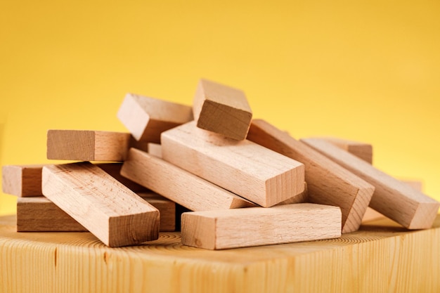 Das Konzept des unternehmerischen Risikos mit dem Jenga-Modell. Holzklötze auf gelbem Grund.