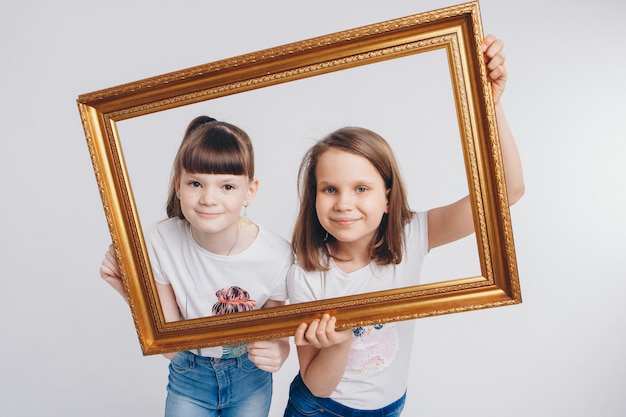 Das Konzept eines gesunden Lebensstils, Kinderschutz, Einkaufen - das sind Teenager, die zusammen spielen. Glückliche Kinder: Schwestern Live-Bild - die Mädchen schauen aus dem Rahmen