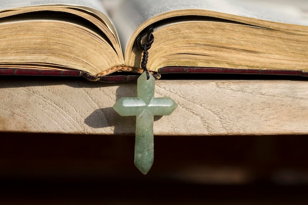 Das Kreuz hängt an der Bibel am Rand des Tisches
