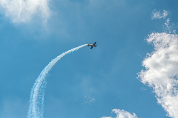 Das Kunstflugzeug mit Rauchspur am Himmel