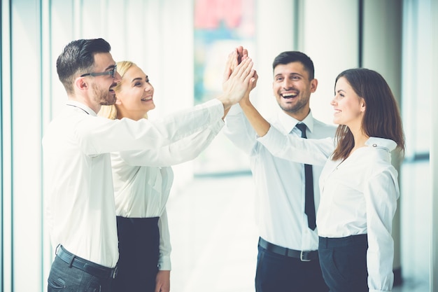 Das Lächeln vier Geschäftsleute, die im Büro grüßen