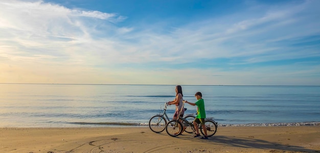 Das Leben einer Mutter-Sohn-Familie auf dem Fahrrad am Sandstrand am Meer