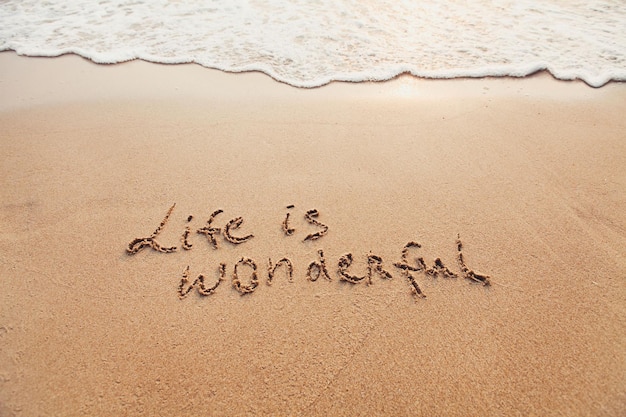 Das Leben ist wunderbar, positives Denken, Konzept, inspirierendes Zitat auf Sand geschrieben.