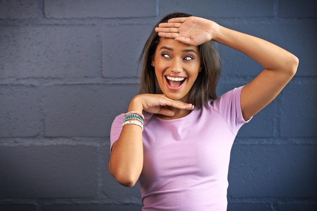 Das Leben macht mehr Spaß, wenn man über den Tellerrand hinausschaut Aufnahme einer jungen Frau, die mit ihren Händen vor einer Backsteinmauer im Hintergrund gestikuliert