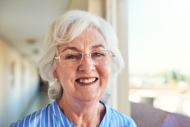 Das Leben mit dem Lächeln ist eine schöne Sache Schnappschuss einer Seniorin zu Hause