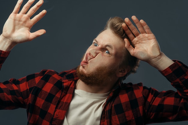 Das lustige Gesicht des Mannes zerquetscht auf transparentem Glas