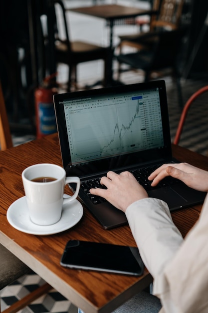 Das Mädchen analysiert die Börse und studiert Finanzen und Wirtschaft bei einer Tasse Kaffee