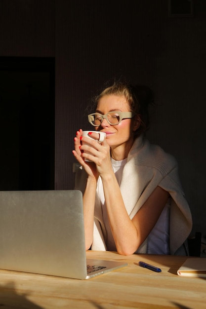 Das Mädchen arbeitet zu Hause an einem Laptop