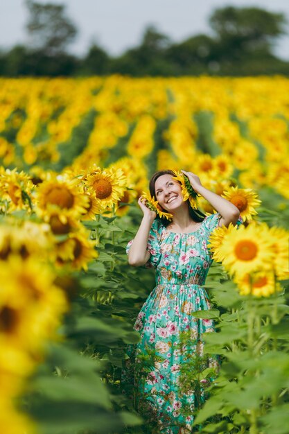 Das Mädchen befestigte Sonnenblumen an ihren Ohren