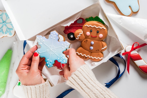 Das Mädchen bereitet sich auf Weihnachten vor und verziert traditionellen Lebkuchen mit mehrfarbiger Zuckerglasur