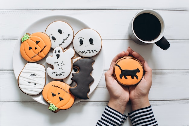 Das Mädchen, das sich für Halloween vorbereiten, Kaffee trinken und beängstigende Lebkuchenplätzchen essen.