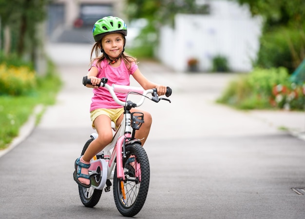 Das Mädchen fährt mit dem Fahrrad auf der Straße