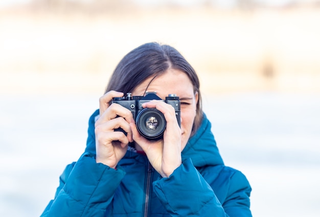 Das Mädchen fotografiert mit einer alten Kamera.