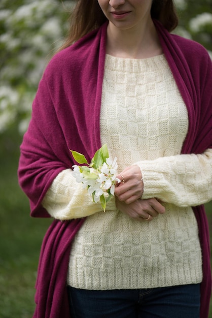 Das Mädchen hält Apfelblüten in der Hand