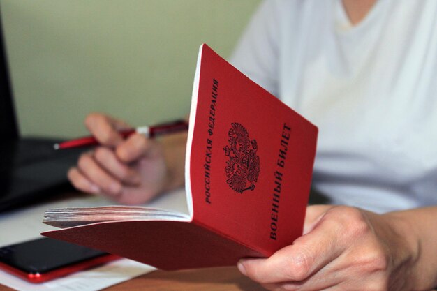 Das Mädchen hält einen von der Russischen Föderation ausgestellten Militärausweis in der Hand und notiert seine Daten